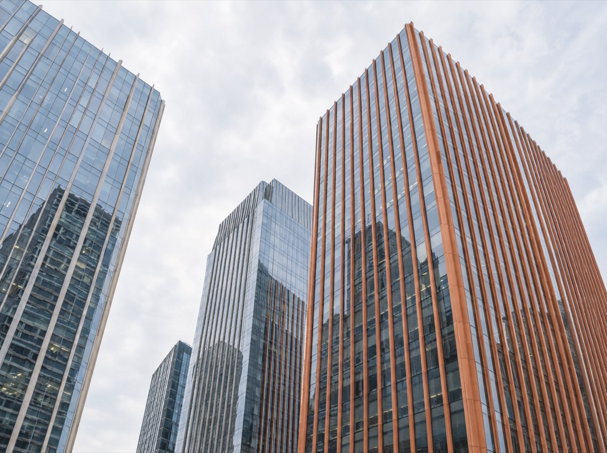 Glass and terracotta office towers seen from below